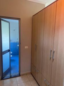 a bathroom with wooden cabinets and a glass door at Lena's Guesthouse in Qerret