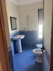 a blue and white bathroom with a sink and a toilet at Lena's Guesthouse in Qerret