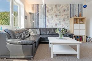 a living room with a leather couch and a table at Fehmarnwelle in Niendorf