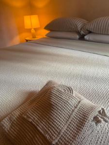 a bed with a blanket on it with a lamp at Suite Atelier Arringo in Ascoli Piceno