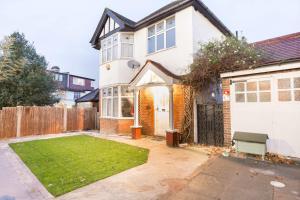 a white house with a lawn in front of it at Stylish 5 Bed Home in Forest Hill Perfect for Business & Contractors Sleeps 16! in Forest Hill