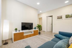 un soggiorno con un divano blu e una TV di Coração da Madeira by Homie a Curral das Freiras