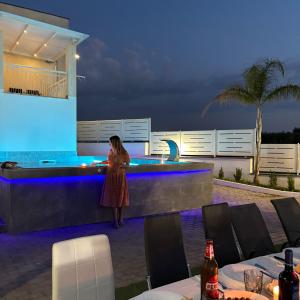 a woman standing at a bar on a patio at night at Villa Manzo relais -Pompei Vesuvius in Boscotrecase +107 photos
