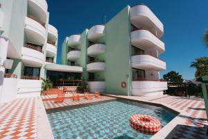 a hotel with a swimming pool and a building at Cubanito Ibiza in San Antonio
