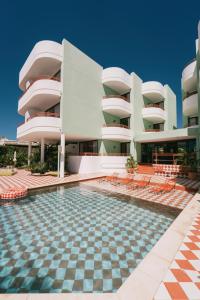 a building with a swimming pool in front of a building at Cubanito Ibiza in San Antonio