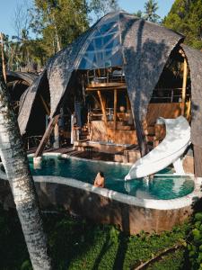 a water slide in a pool with a house at Veluvana Mountain in Sidemen +57 photos