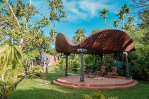 a wooden pavilion in a garden with chairs at Madilina Heritage Villa in Parūr