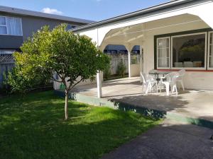 a patio with a table and chairs and a tree at Central Spacious House With Backyard And Patio in Palmerston North