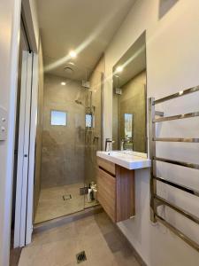 a bathroom with a sink and a shower at Luxury corner 2BR Townhouse with parking in Christchurch +18 photos