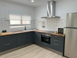 a kitchen with black cabinets and a stainless steel refrigerator at Casa Barrionuevo 2 in La Granja de San Ildefonso