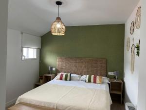 a bedroom with a large bed and a green wall at Casa Barrionuevo 2 in La Granja de San Ildefonso