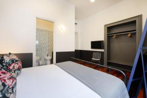 ein Schlafzimmer mit einem weißen Bett und ein Badezimmer in der Unterkunft Salotto Borbonico - Sanfelice in Neapel