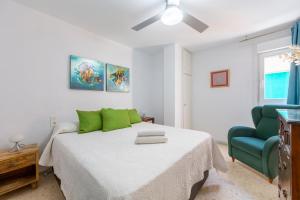 a bedroom with a bed and a green chair at Aguadulce Beach in Aguadulce