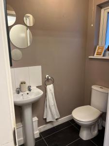 ein Badezimmer mit einer weißen Toilette und einem Waschbecken in der Unterkunft 5 Bedroom Contractors Accommodation in Dartford Kent - Spacious Holiday Home - Close To Dartford Crossing - Close To City Centre in Dartford + 25 Fotos