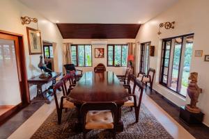 a dining room with a wooden table and chairs at Madilina Heritage Villa in Parūr