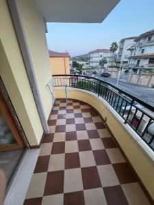 a balcony with a checkerboard floor and a bridge at Appartamento CIVICO CHIC in Mandatoriccio Marina