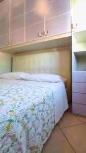 a bedroom with a bed with white sheets and cabinets at Flat n 11 Vista Mare in Alba Adriatica