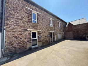 a brick building with a driveway in front of it at Appartement meublé T2 PONT REAN - Centre in Guichen
