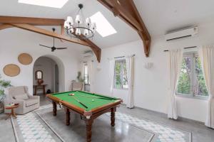 una sala de estar con una mesa de billar en Villa Mandarina - Luxury 4BHK Villa Near Morjim Beach with Pvt Pool, Pool Table & Kids Playground, en Siolim