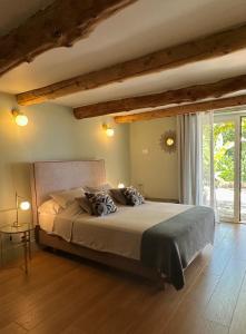 a bedroom with a large bed and a large window at Domaine des Encourdoules in Vallauris