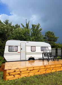 a white rv parked on a wooden deck at Majakatare Holiday Homes in Maasi