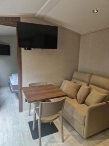 a living room with a couch and a table at Cabane des Catalpas in Vollore-Ville