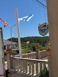 latawiec latający na niebie nad budynkiem w obiekcie Hostal Restaurante Pinarejo w mieście A Lanzada