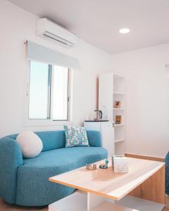 a living room with a blue couch and a table at Arka - Studio B in Anfah