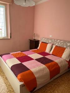 sypialnia z dużym łóżkiem z kolorową kołdrą w obiekcie Affittacamere Room Rental Pisa w Pizie