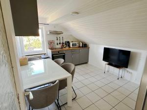a kitchen with a table and a tv in a room at Comfort Stay Apartment in Rüsselsheim am Main in Rüsselsheim