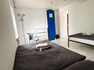 a bedroom with a bed and a dresser and a chair at Comfort Stay Apartment in Rüsselsheim am Main in Rüsselsheim