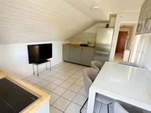a kitchen with a table and a tv in a room at Comfort Stay Apartment in Rüsselsheim am Main in Rüsselsheim