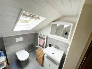 a bathroom with a white sink and a toilet at Comfort Stay Apartment in Rüsselsheim am Main in Rüsselsheim