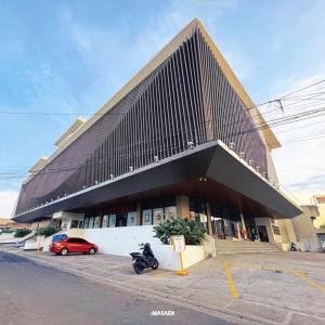 Un edificio con una motocicleta estacionada enfrente. en Downtown District Hotel, en Naga