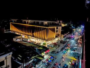 a building on a city street at night at Downtown District Hotel in Naga