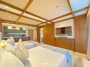a large room with white couches and a tv at Downtown District Hotel in Naga