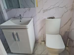 a bathroom with a white toilet and a sink at Room Four in Earley