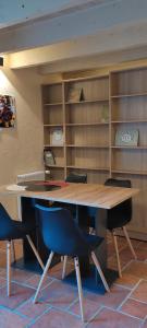 a table and chairs in a room with shelves at Appartement La veg'it in Seyssins