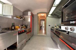 a kitchen with stainless steel appliances and a hallway at Villa della Contessa Cangini di Volterra con piscina e parco privato in Castiglioncello