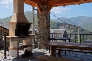 a patio with a pizza oven and a picnic table at Pisos Leopoldo - Casaio in Casayo