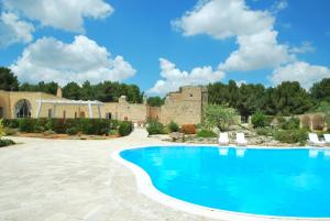 サンニコーラにあるMasseria Relais Santa Teresaの城を背景にした庭のスイミングプール +88枚の写真