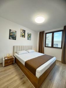 a bedroom with a large bed and a window at Cabacum Pleasure Beachfront Apartments in Varna City +6 photos