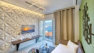a living room with a tv on a wall at Well Being Luxury Apartments in Évdhilos
