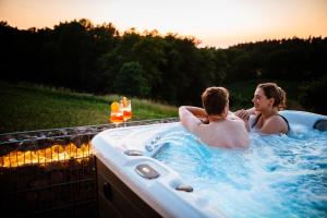 two people in a jacuzzi tub with the sunset at Chalet Heimatzeit in Reichenbach