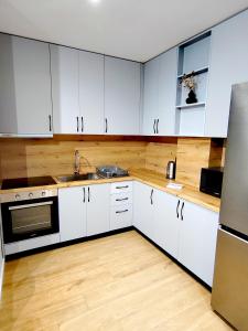 a kitchen with white cabinets and a sink at MiKi Apartmán Durrës in Durrës