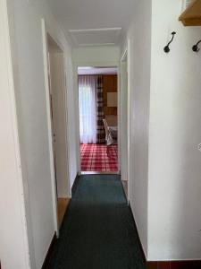 an empty room with a hallway leading to a living room at Le Petit Chalet Gentinetta in Leukerbad