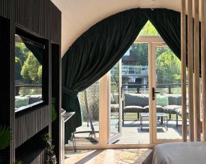 马斯顿格林AvantGlamp的卧室设有滑动玻璃门,可通往庭院。