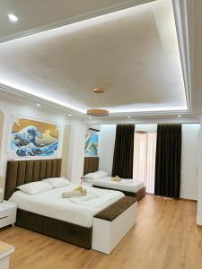 a bedroom with two beds and a painting on the wall at Bamisa apartamets in Golem