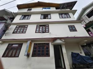 a white house with windows and a door at Hotel O Sun View in Gangtok