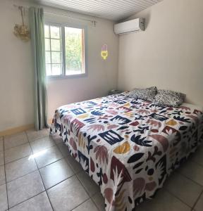a bedroom with a bed with a colorful comforter at KaZandoli in Les Anses-dʼArlets +49 photos